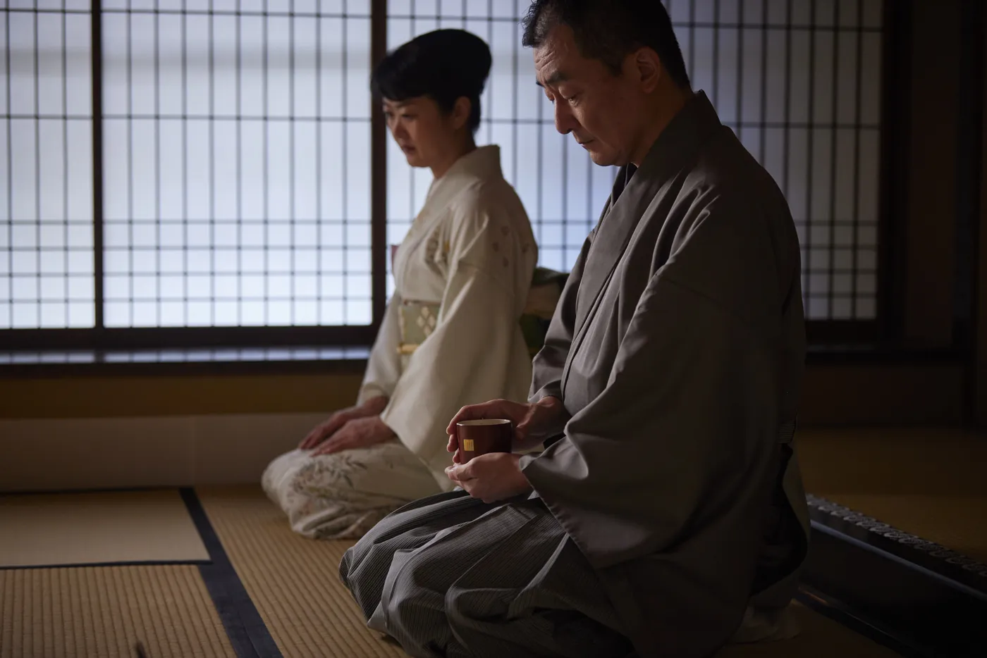 障子の前で聞香炉を手に香を聞く二人